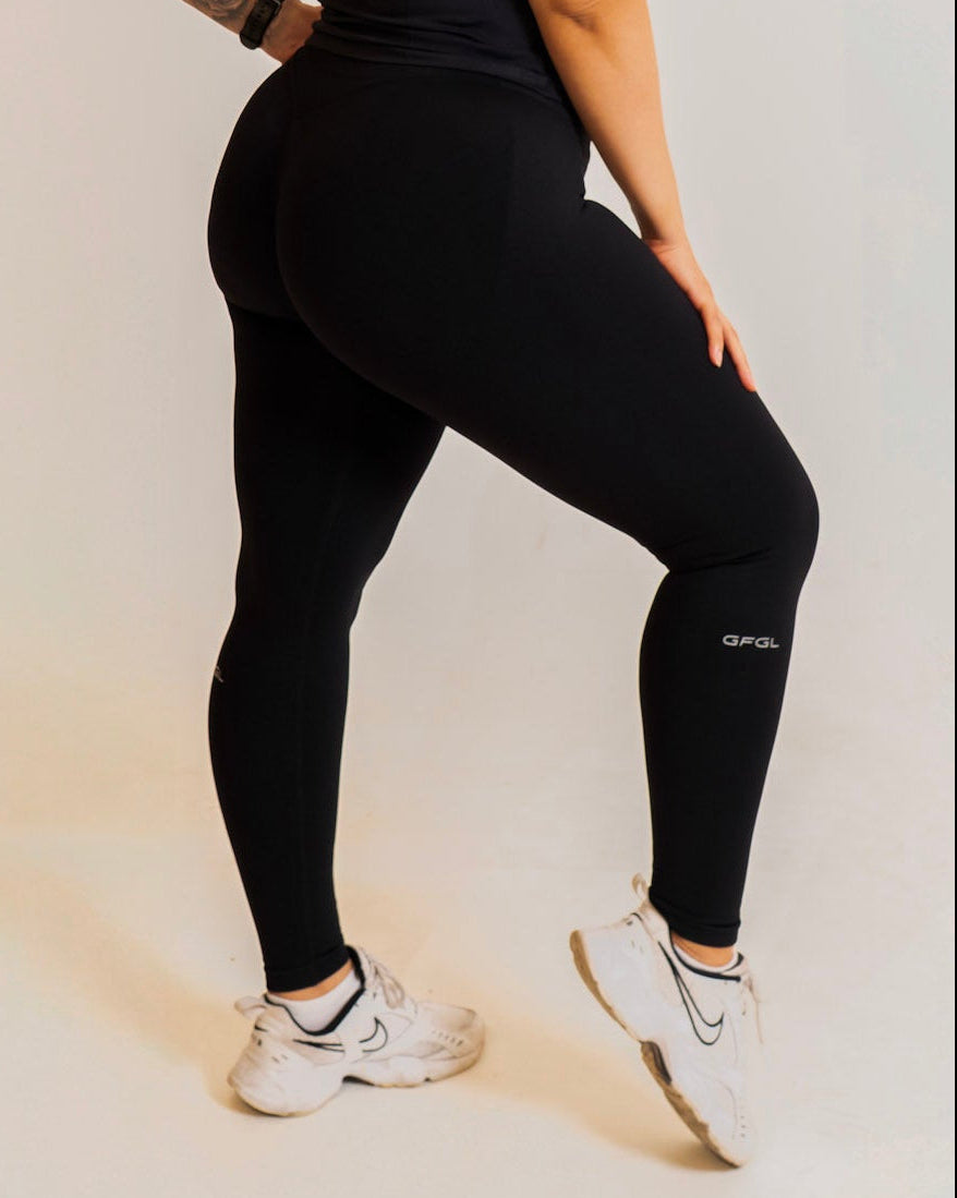 Person wearing a black athletic outfit with visible branding on a plain background