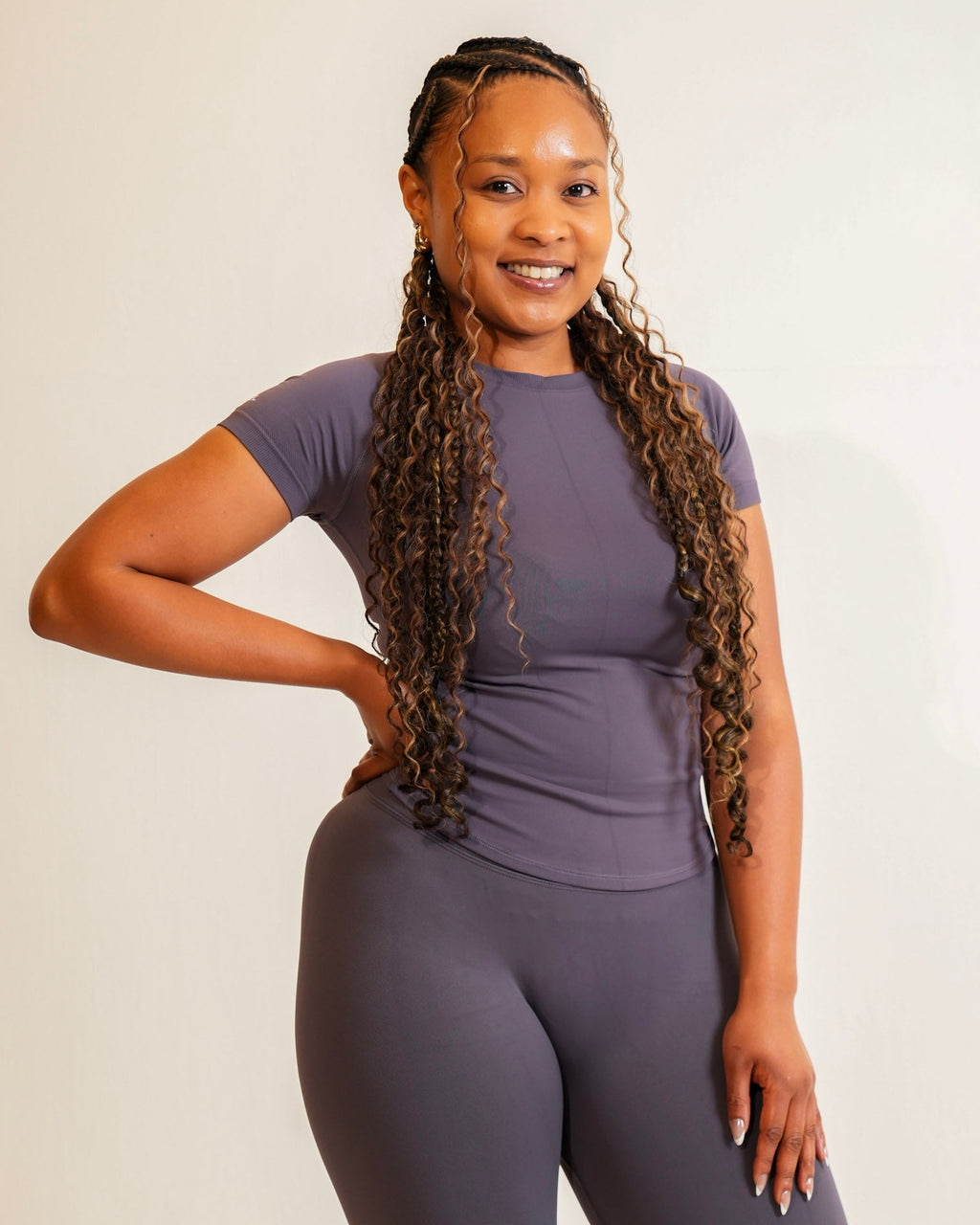 Woman wearing a purple athletic outfit on a beige background