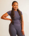 Woman wearing a purple athletic outfit on a beige background