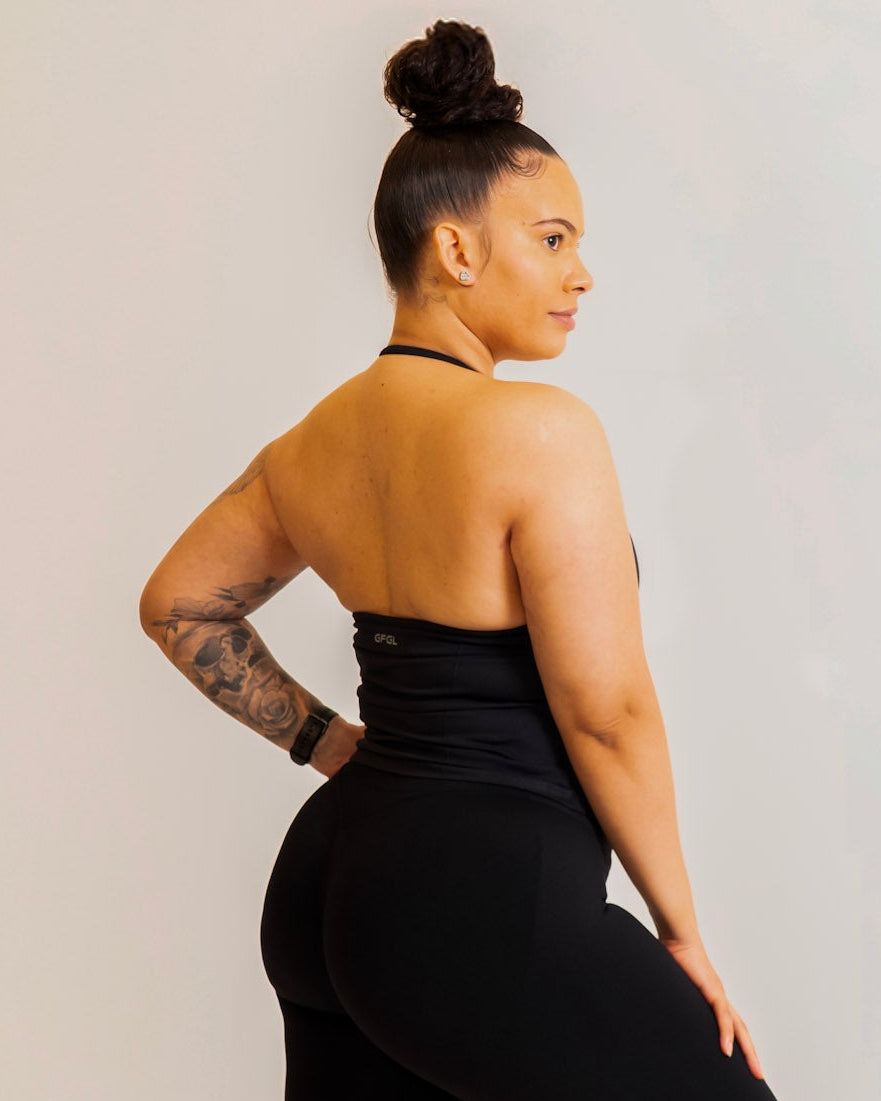 Person wearing a black athletic outfit with visible branding on a plain background