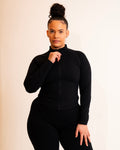 Person wearing a black long-sleeve top and black pants on a beige background