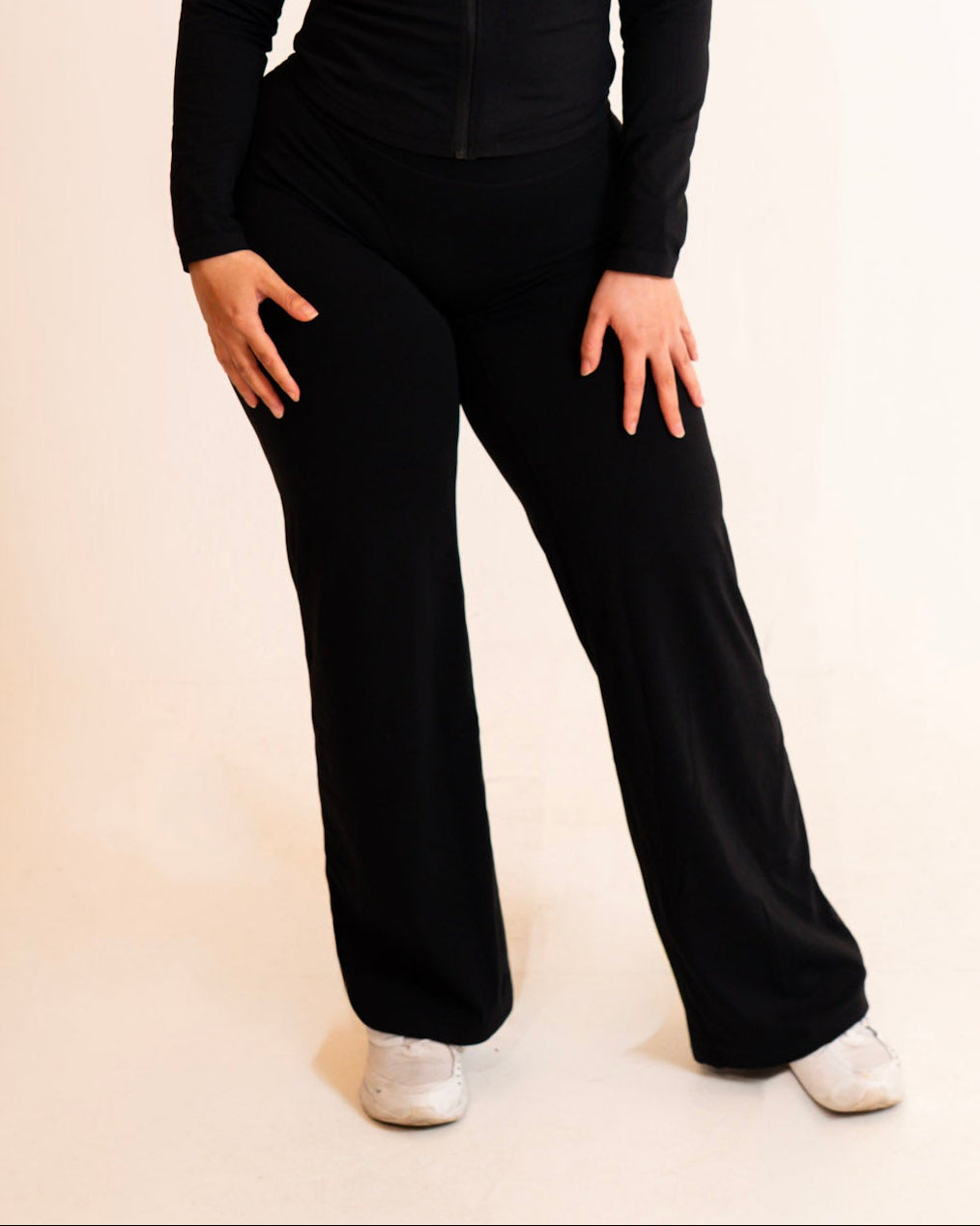 Person wearing a black outfit on a plain background