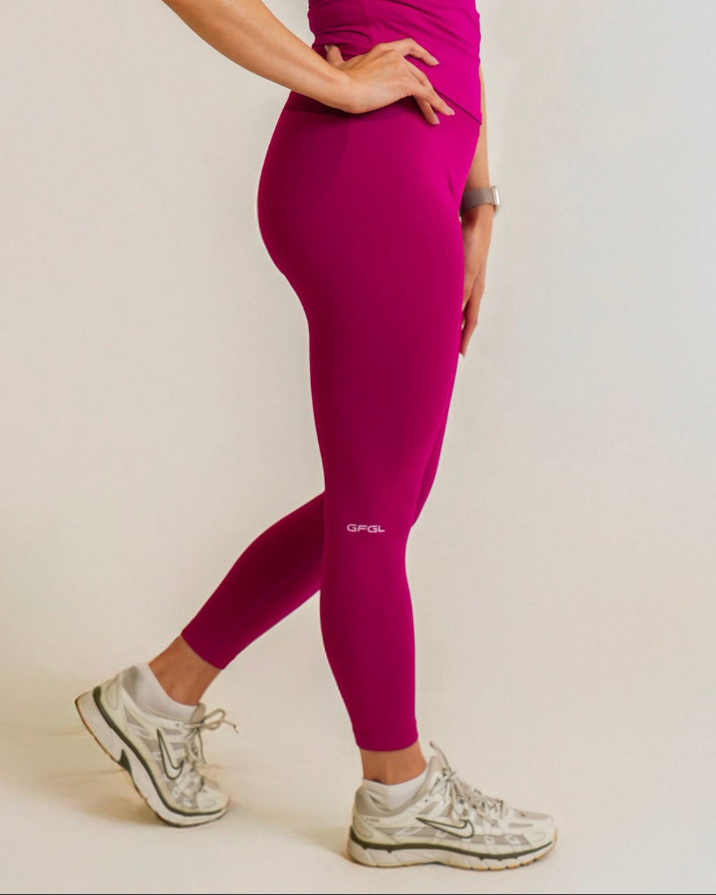 Woman wearing a pink athletic outfit on a white background